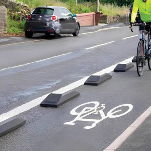 Man riding a bike with Narrow Bike Lane Defender protecting him from street cars.